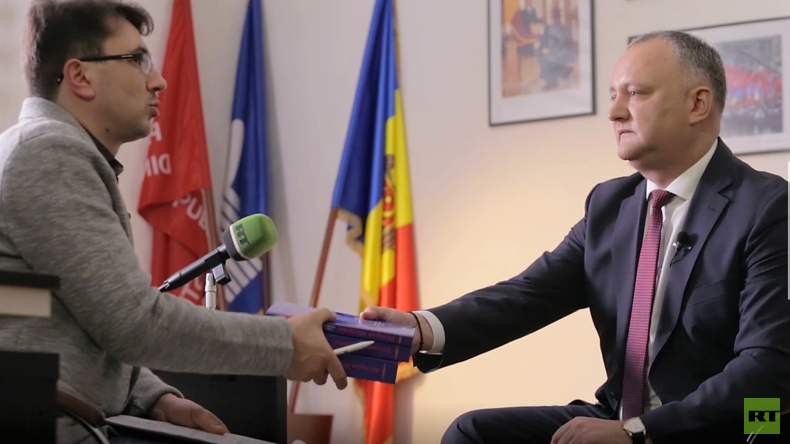 Der moldawische Präsident Igor Dodon überreicht sein Geschenk dem RT Deutsch-Redakteur Wladislaw Sankin: Die dreibändige Geschichte Moldawiens in russischer Sprache.