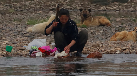 Eine Nordkoreanerin wäscht im Fluss von Sinuiju ihre Wäsche; Nordkorea, 16. April 2017.