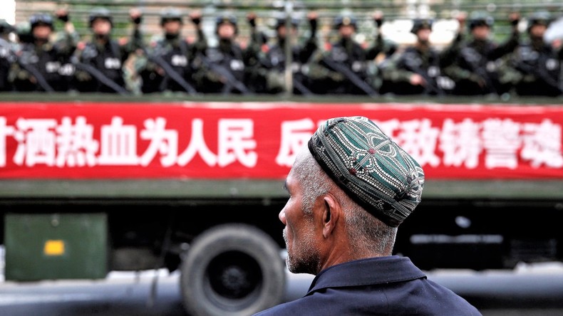 Ein Uigure , bewaffnete Polizisten in Xinjing, China